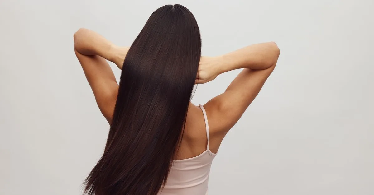 A woman with long, sleek healthy hair from behind