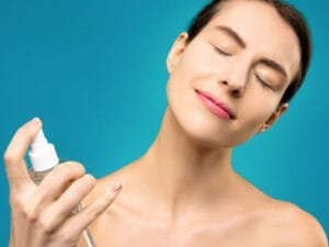 A woman misting her face with a spray bottle