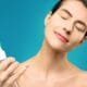 A woman misting her face with a spray bottle