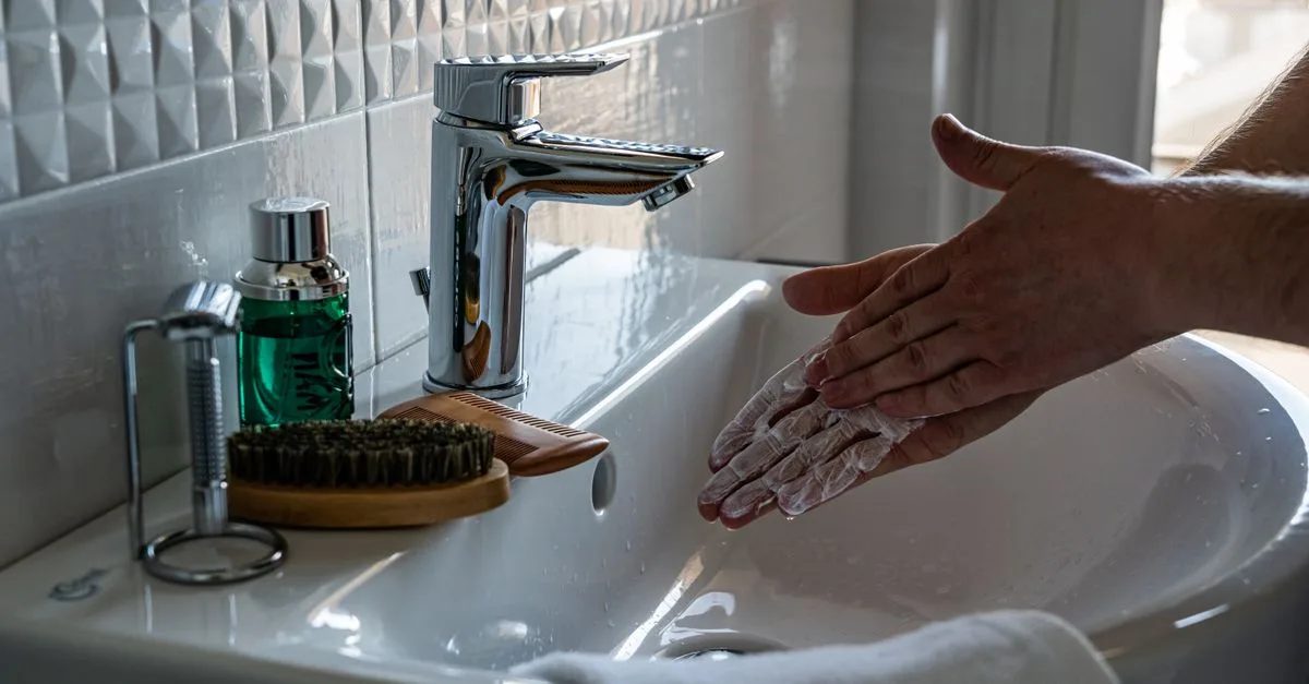 Hands washing at a bathroom sink