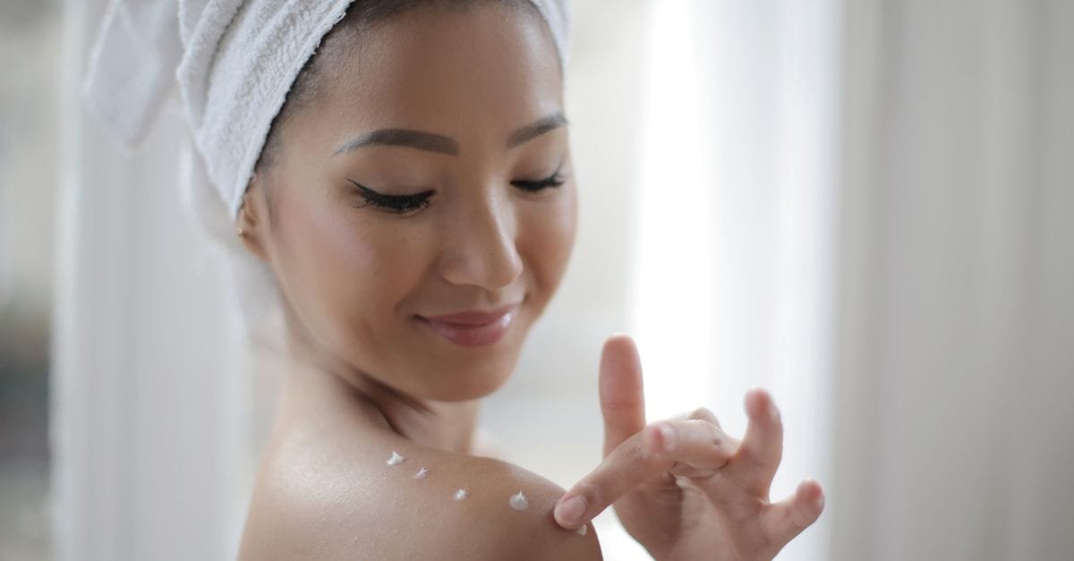 A towel-wrapped woman applying product