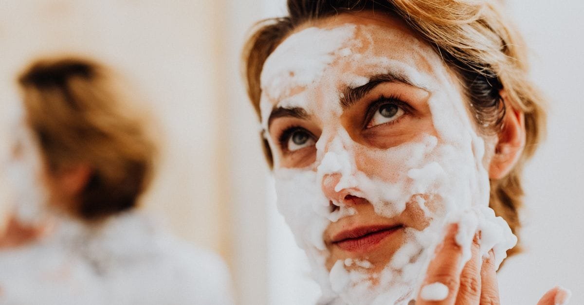 A woman with cleanser foam on her face