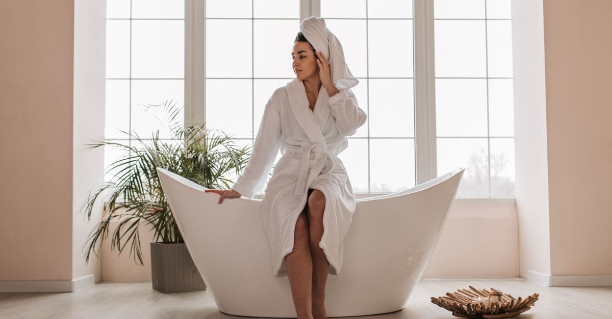 A woman in a robe sitting by a bright window