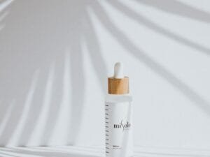 A minimal serum bottle in soft palm-leaf light