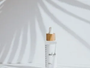 A minimal serum bottle in soft palm-leaf light