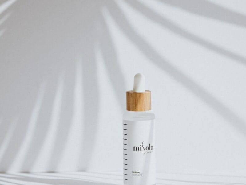 A minimal serum bottle in soft palm-leaf light