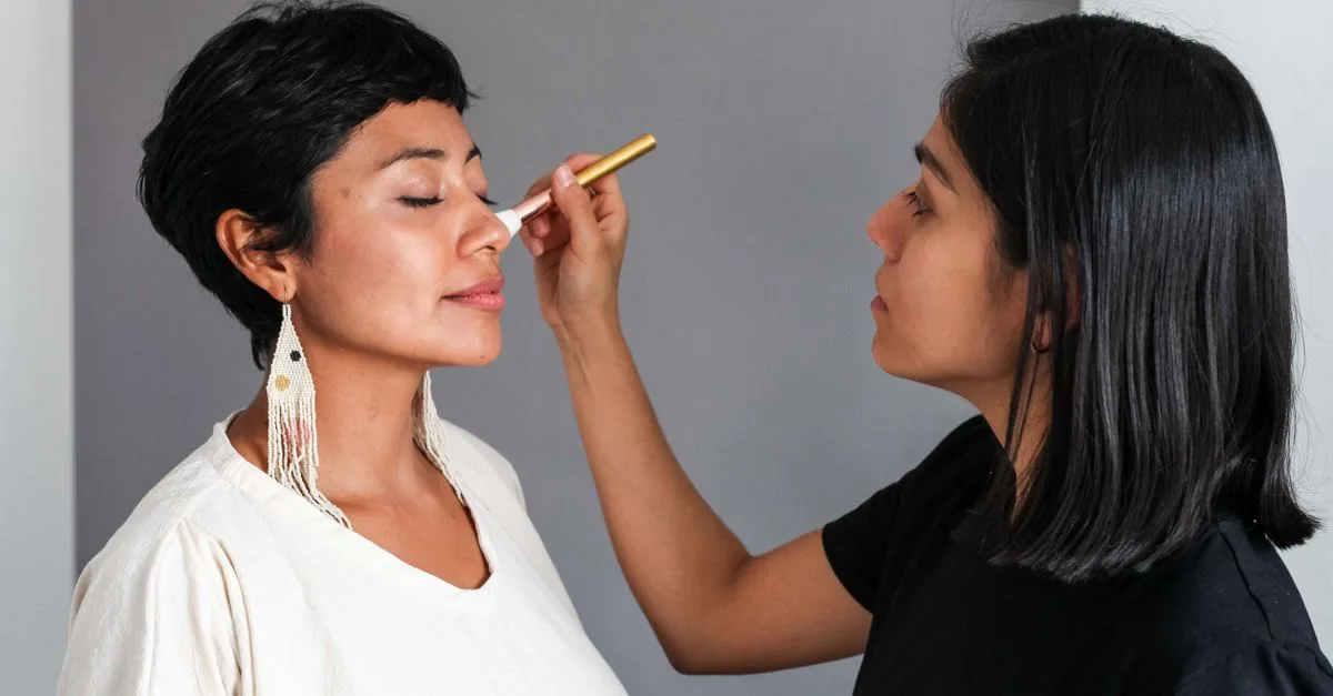 A makeup artist applying blush to a client
