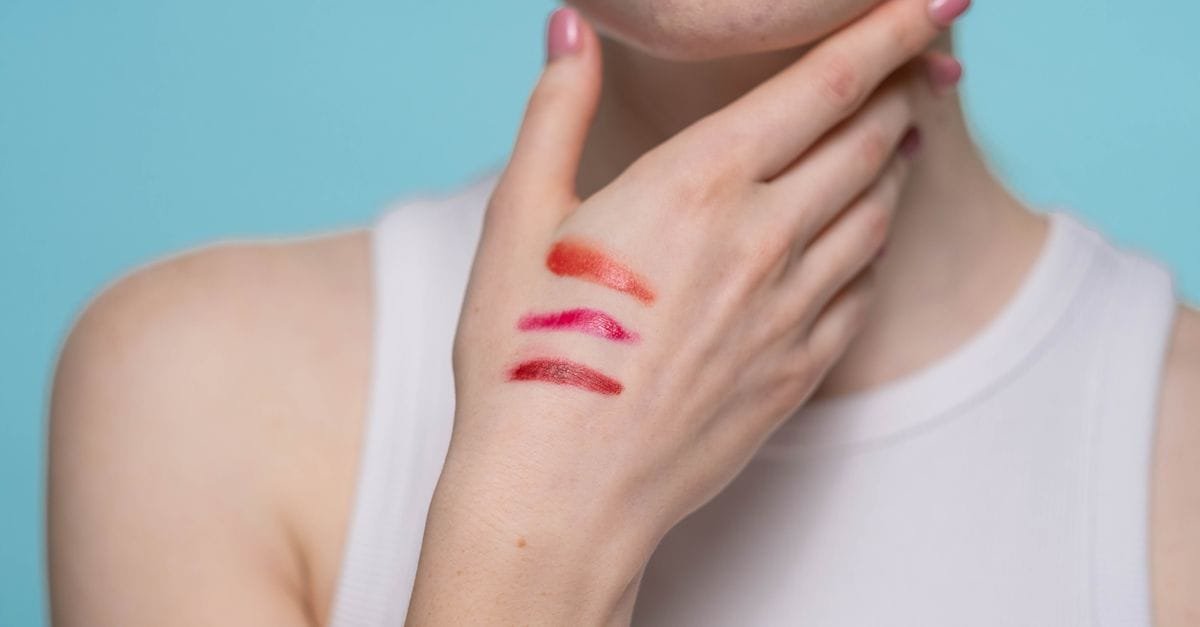 Lip color swatches on a woman&rsquo;s neckline