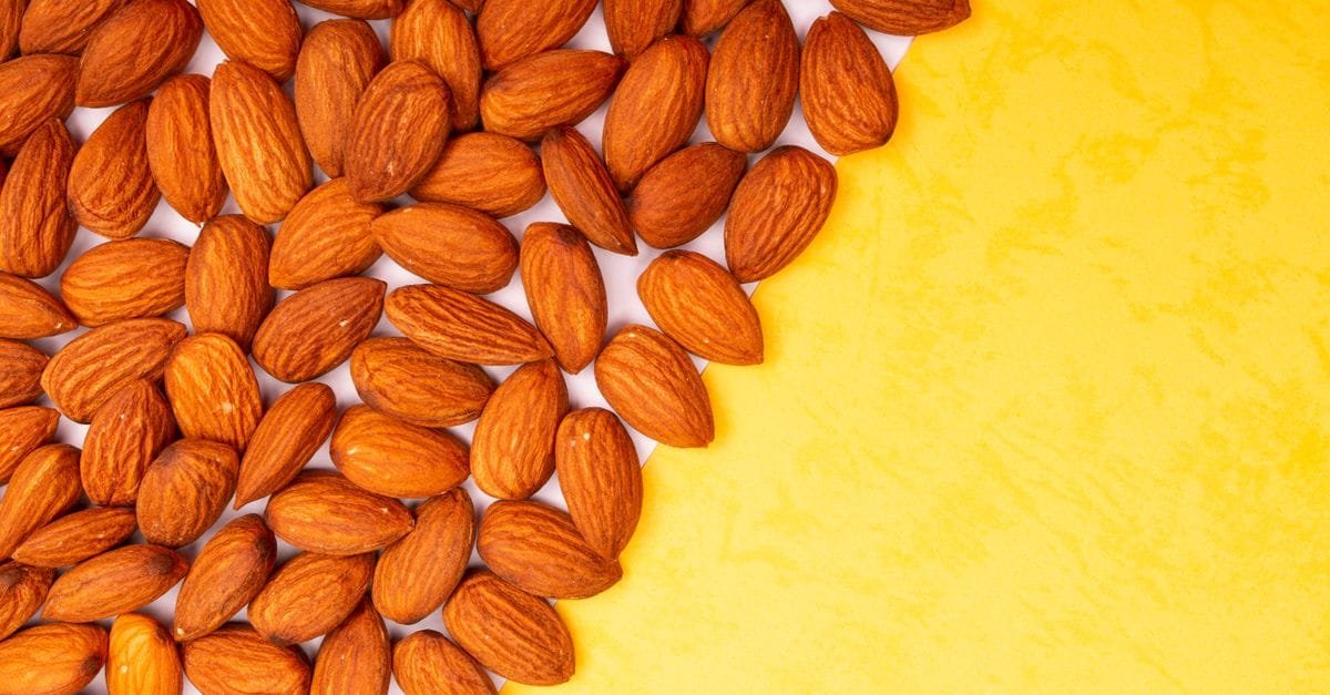 A spread of almonds on a yellow surface