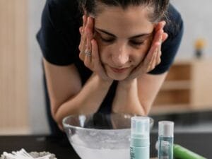 A woman washing her face over a basin